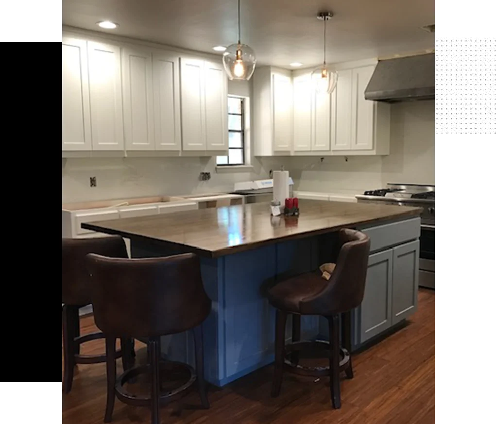 A kitchen with a large island and white cabinets.