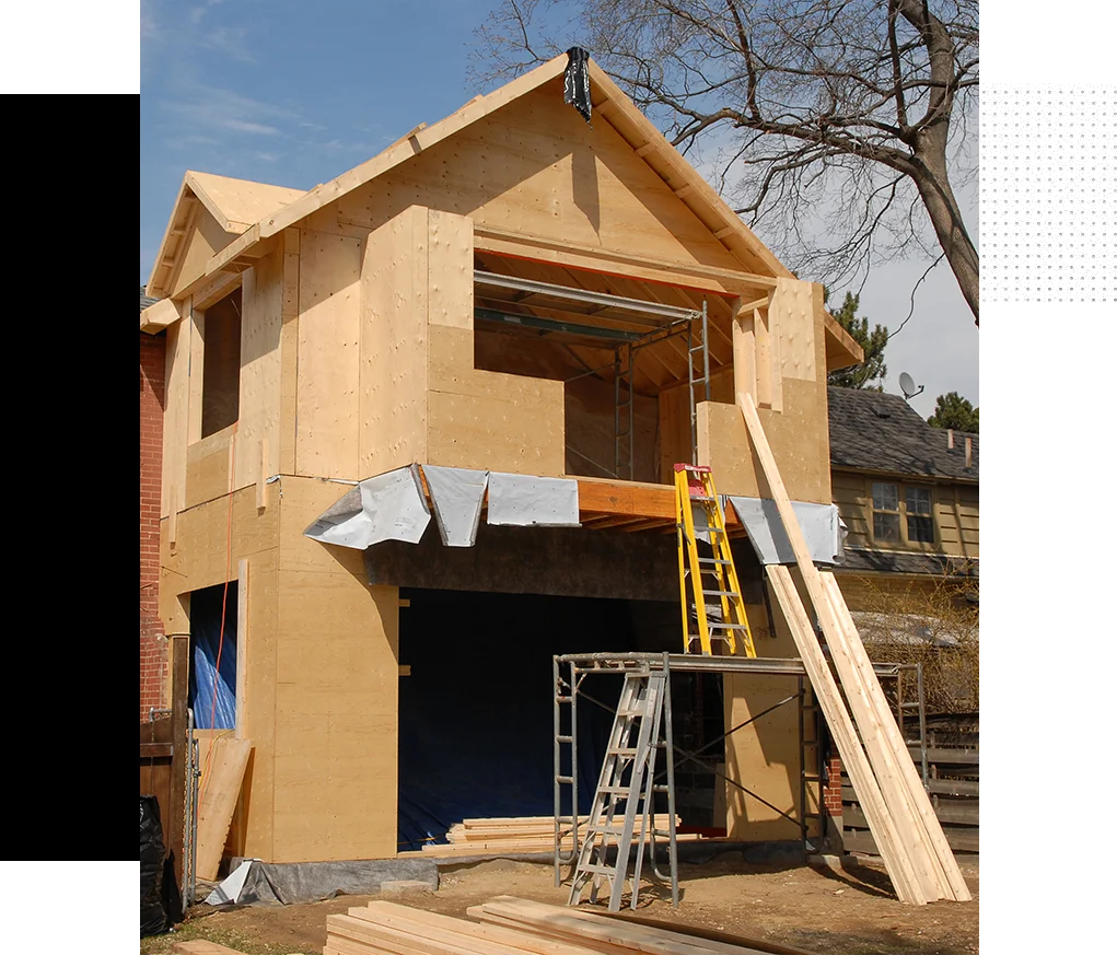 A house being built with some materials in the process of construction.