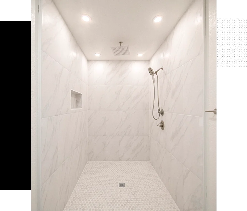 A white shower with lights on the ceiling.