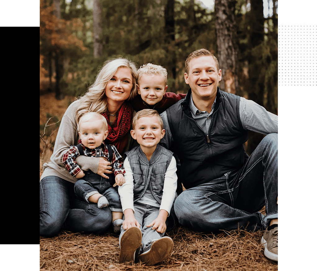 A family posing for a picture in the woods.