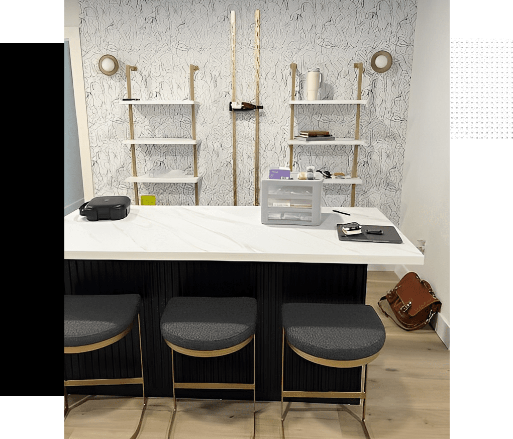 A room with a table and chairs, shelves and a laptop.