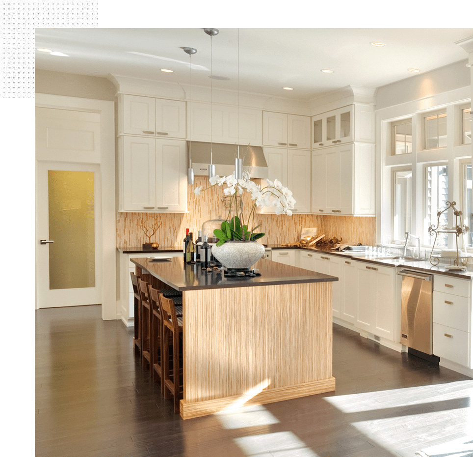 A kitchen with white cabinets and black counter tops.